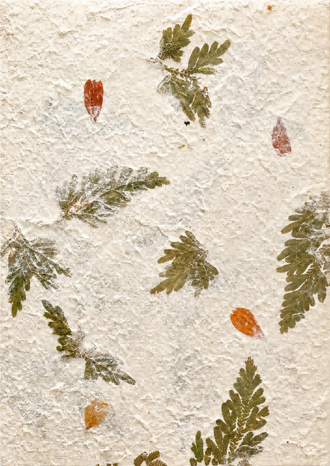 Handmade botanical paper with pressed fern-like foliage, small yellow flowers and a natural textured surface